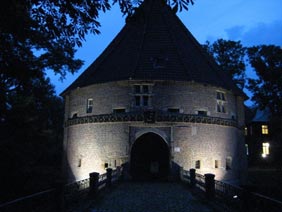Bei Nacht: Torhaus von Schloss Bladenhorst mit Panther